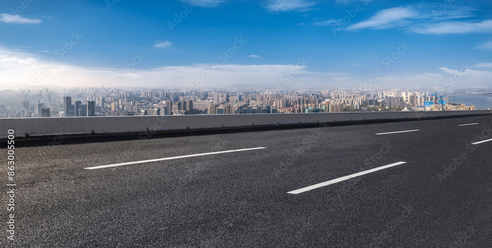 Fototapeta premium Urban Highway Overlooking Cityscape with Blue Sky