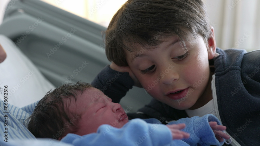 Young boy watching his newborn baby brother at hospital after birth, authentic real life siblings meeting for the first time, day one of infant being welcomed by family at clinic Young boy watching his newborn baby brother at hospital after birth, authentic real life siblings meeting for the first time, day one of infant being welcomed by family at clinic