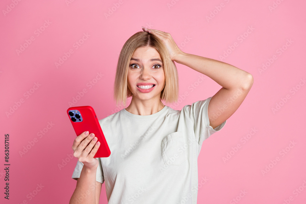 Photo of confused guilty puzzled woman with bob hairdo dressed t-shirt holding smartphone palm on head isolated on pink color background Photo of confused guilty puzzled woman with bob hairdo dressed t-shirt holding smartphone palm on head isolated on pink color background