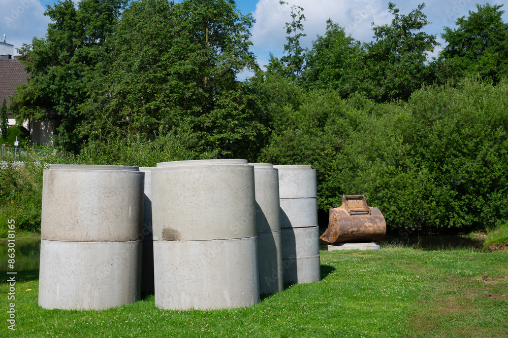 Cylindrical concrete rings for sewer points folded on a green lawn Cylindrical concrete rings for sewer points folded on a green lawn