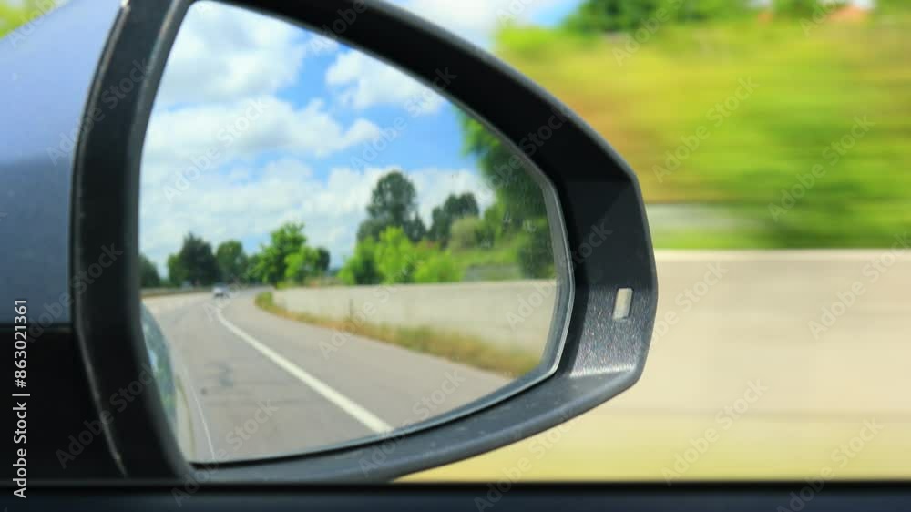 Video shooting in motion, view in the rear view side mirror of a auto, driving a red car along the road Video shooting in motion, view in the rear view side mirror of a auto, driving a red car along the road