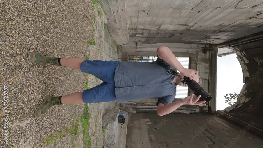 A male photographer with a camera takes a photo on a summer day, exploring the ancient city.