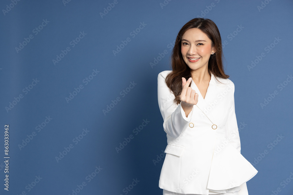 Young Asian businesswoman show mini heart isolated on blue background, Valentine day concept Young Asian businesswoman show mini heart isolated on blue background, Valentine day concept