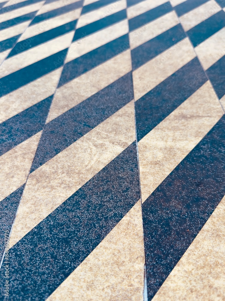 Fototapeta premium A yellow and black caution paint sidewalk crosswalk ensures pedestrian safety with bold, high-contrast stripes, clearly marking crossing areas and enhancing visibility for both walkers and drivers.