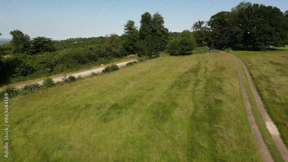 Rising drone shot of farmland and the Weald of Kent, looking west over the village of Bought Monchelsea, near Maidstone, Kent, UK. June