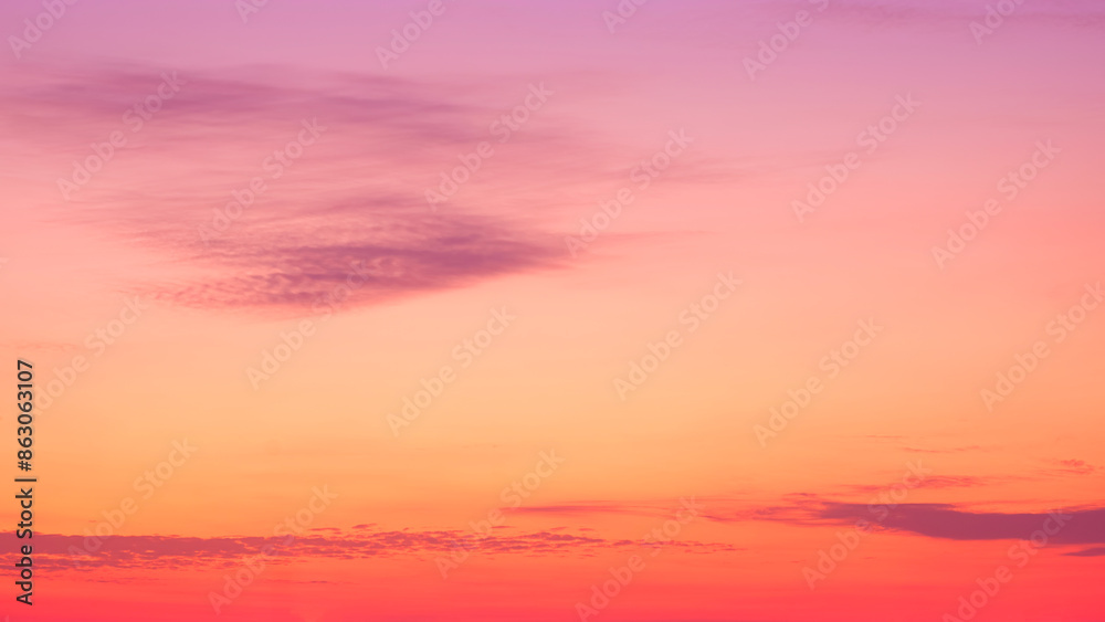 Fototapeta premium Colorful orange sunset sky in the evening with dark cloud streaks on beautiful sunrise sky background, Idyllic natural tranquil scene