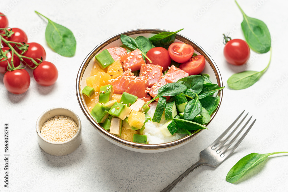 Salmon bowl with spinach, rice, avocado, tomato, cucumbers on a white background, top view. Poke bowl, healthy eating Salmon bowl with spinach, rice, avocado, tomato, cucumbers on a white background, top view. Poke bowl, healthy eating