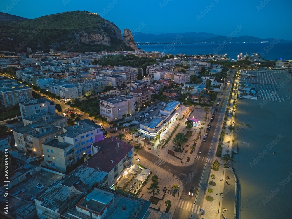 Fototapeta premium Beaches of Terracina, Italy, at dusk. The Roman temple of Jupiter can be seen on top of the hill beyond the city.
