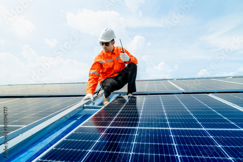 engineer man inspects construction of solar cell panel or photovoltaic cell by electronic device. Industrial Renewable energy of green power. factory worker working on tower roof. © ultramansk
