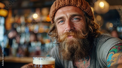 A bearded man wearing a knit hat, enjoying a drink in a cozy rustic bar, surrounded by warm lighting and a relaxed atmosphere that evokes a sense of contentment. photo