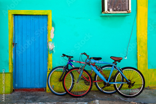 Two old bicycles parked against a colorful home in Isla Mujeres, Mexico
