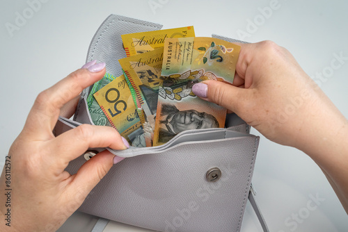 woman hold australian dollar paper bank note cash bills with grey bag. Rremoving money from wallet