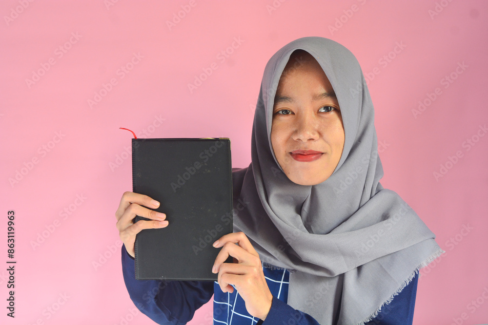 Portrait of Asian woman reading a book on isolated pink background Portrait of Asian woman reading a book on isolated pink background