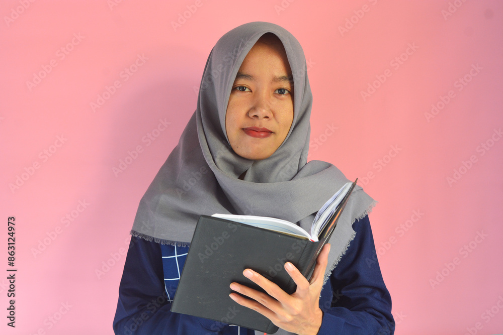 Portrait of Asian woman reading a book on isolated pink background Portrait of Asian woman reading a book on isolated pink background
