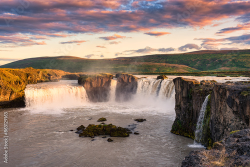 Godafoss waterfall flowing with colorful sunset sky in summer at Iceland