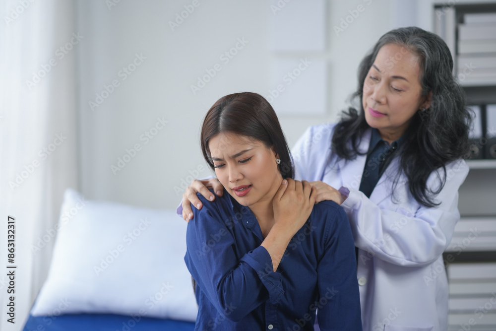 A healthcare professional assists a patient experiencing shoulder pain in a bright, modern medical office. A healthcare professional assists a patient experiencing shoulder pain in a bright, modern medical office.