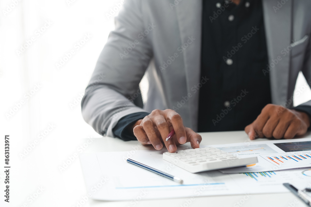 Businessman analyzing financial charts and using calculator for investment Businessman analyzing financial charts and using calculator for investment