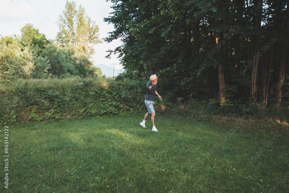 Black-haired athlete plays a friendly football match on the lawn. Amateur sport. Man playing with a ball. Dribbling practice. Sport lifestyle Black-haired athlete plays a friendly football match on the lawn. Amateur sport. Man playing with a ball. Dribbling practice. Sport lifestyle