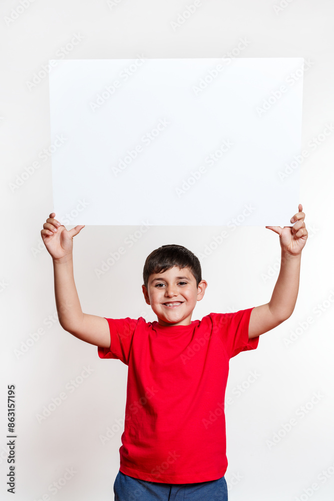 A young boy is holding a white sign in his hand A young boy is holding a white sign in his hand
