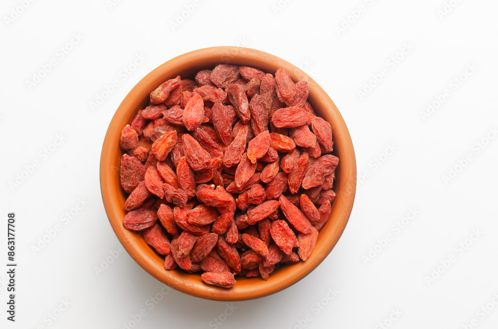 Goji berries in a brown ceramic bowl on a white background. Oriental superfood. Healthy food concept. Goji berries in a brown ceramic bowl on a white background. Oriental superfood. Healthy food concept.