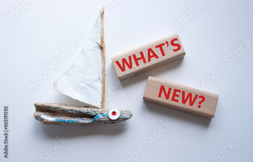 What is new symbol. Concept word What is new on wooden blocks. Beautiful white background with boat. Business and What is new concept. Copy space photo