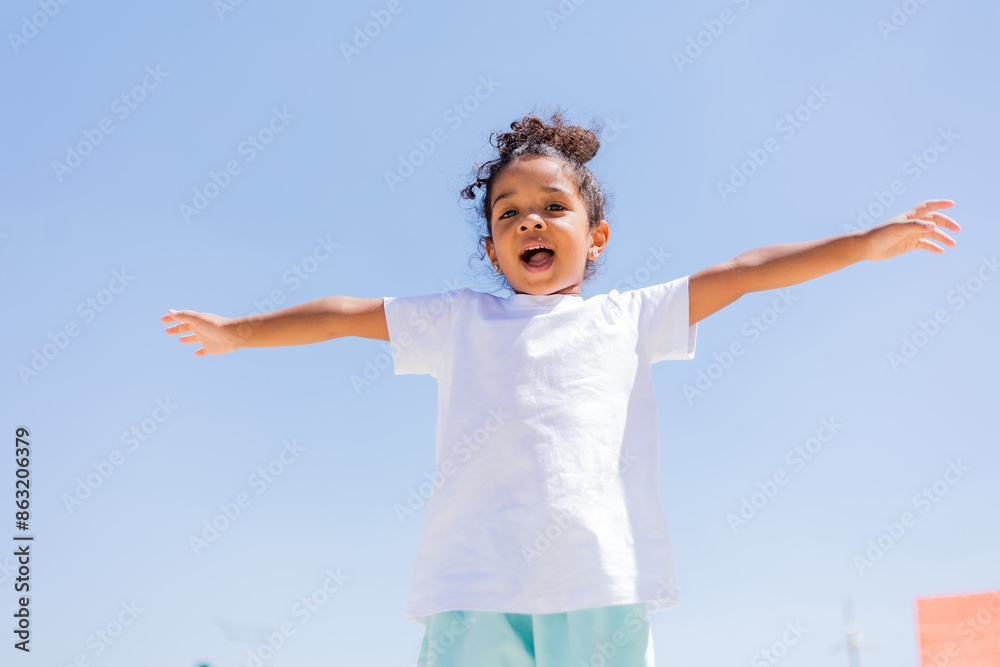 A little mulatto girl plays in the sandbox on the playground