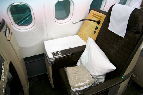 ZURICH, SWITZERLAND - JUNE 22, 2019: Empty cabin with business class seats with wood applications and brown fabric in a long-haul aircraft on the flight from Dubai to Zurich