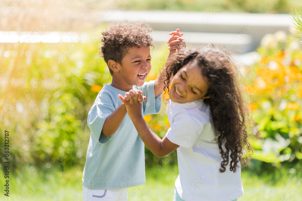Naklejka premium small mulatto children a boy and a girl on a summer walk