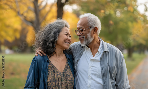 Happy vibrant senior couple smiling and walking together in a park 