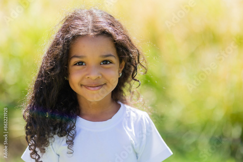 Foto little mulatto girl in a white T-shirt on a summer walk