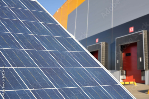 Element of a solar power plant against the background of a modern logistics center.