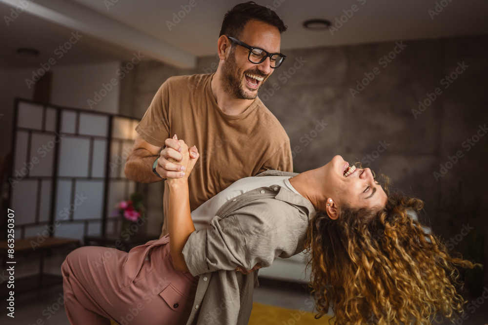 Fototapeta premium Happy in love couple man woman husband and wife dance at home have fun