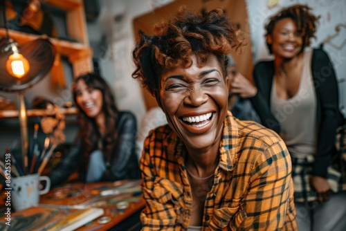 A joyful senior lady artist is enjoying her painting activity in a lively studio, surrounded by other smiling individuals, indicating a cheerful and creative atmosphere.