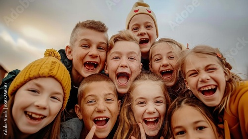 A group of cheerful and diverse children smiling and laughing together in an outdoor setting. The photo captures their joy and happiness, highlighting their friendship. © neatlynatly