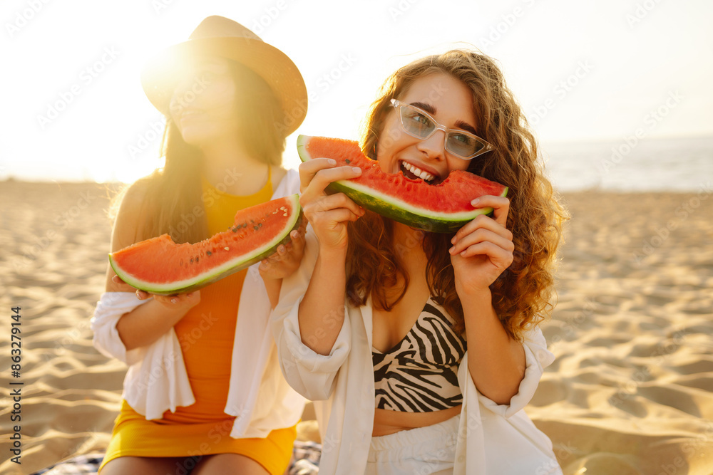 Two laughing women with watermelon on beach. Picnic. People, lifestyle, travel, nature and vacations concept. Two laughing women with watermelon on beach. Picnic. People, lifestyle, travel, nature and vacations concept.