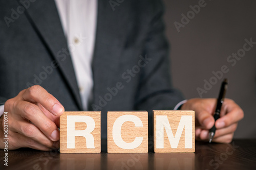 There is wood cube with the word RCM. It is as an eye-catching image.