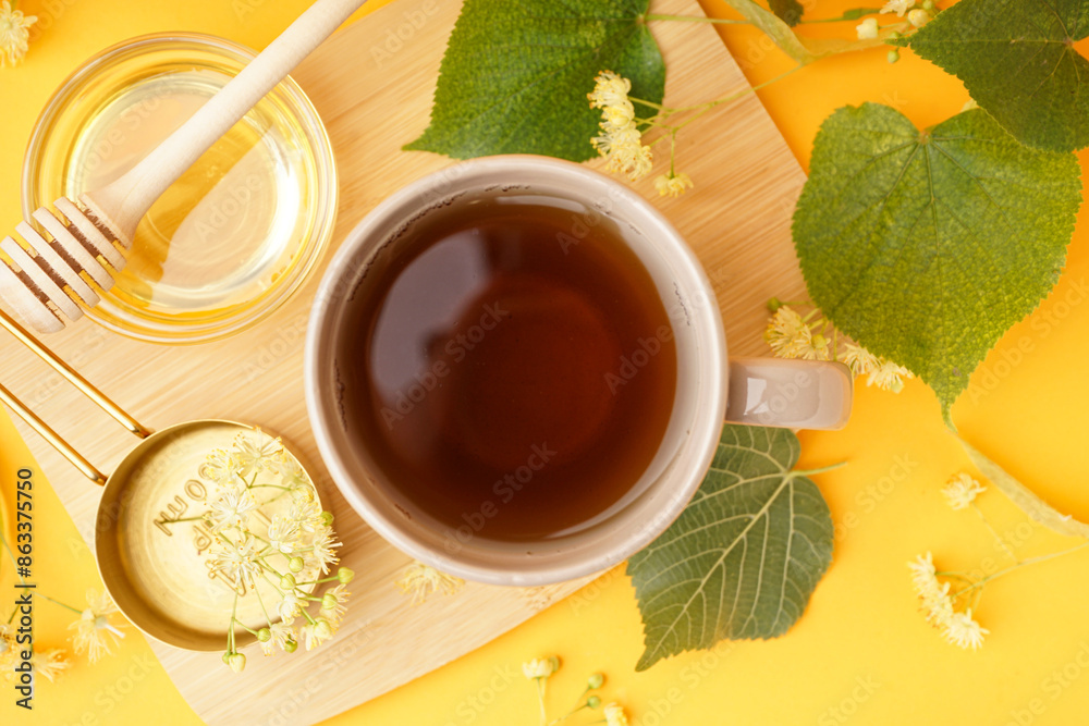 Fototapeta premium Cup of linden tea and bowl with honey on orange background