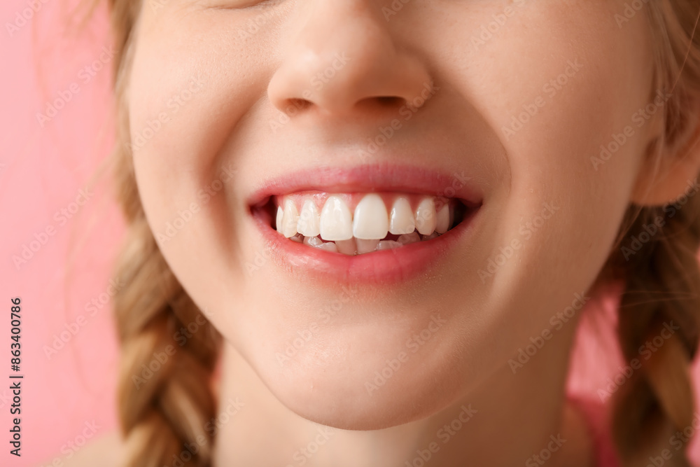 Obraz premium Teenage girl smiling on pink background, closeup