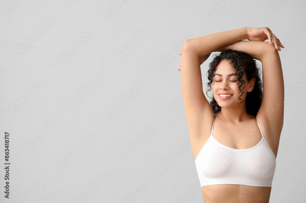 Fototapeta premium Beautiful young African-American woman on grey background