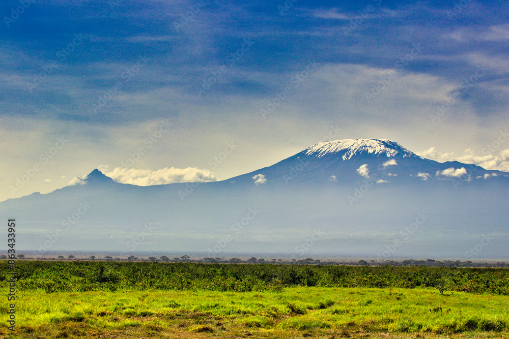 Obraz premium Mount Kilimanjaro Kibo and Mawenzie peaks present postcard perfect views over the vast Amboseli national park savanna in a classical African scene in Kenya