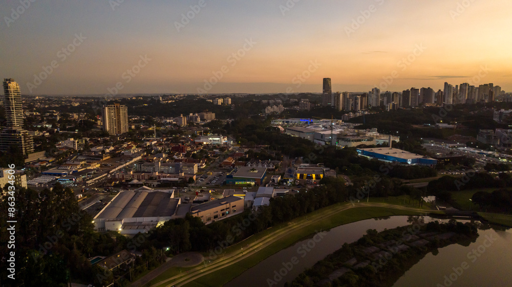 Obraz premium Curitiba in Paraná, Brazil. Aerial View. Wonderful sunset with views of buildings and Tanguá Park. Lake with reflection..