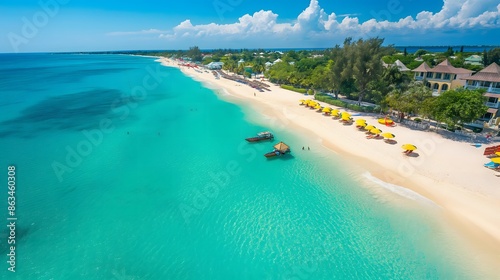 5. High-angle view of Seven Mile Beach, capturing its long stretch of coastline lined with beachfront bars and vibrant beach umbrellas, offering a perfect blend of relaxation and tropical paradise.