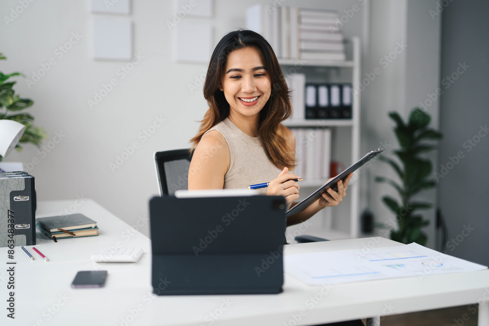 Confident Asian Business Woman Working at Modern Office Desk with Tablet and Documents Confident Asian Business Woman Working at Modern Office Desk with Tablet and Documents