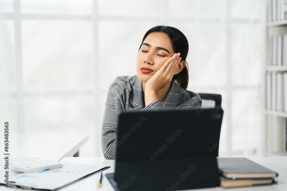 Asian Business Woman Taking a Break at Office Desk with Laptop and Documents in Modern Workspace Asian Business Woman Taking a Break at Office Desk with Laptop and Documents in Modern Workspace