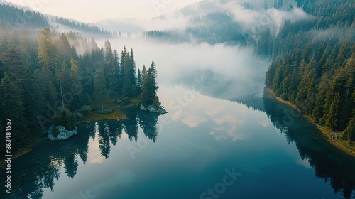 Drone photo of a mountain lake at dawn, with mist hovering over the calm water, surrounded by lush pine forests, reflected in the crystal-clear water, vivid colors, serene atmosphere. photo