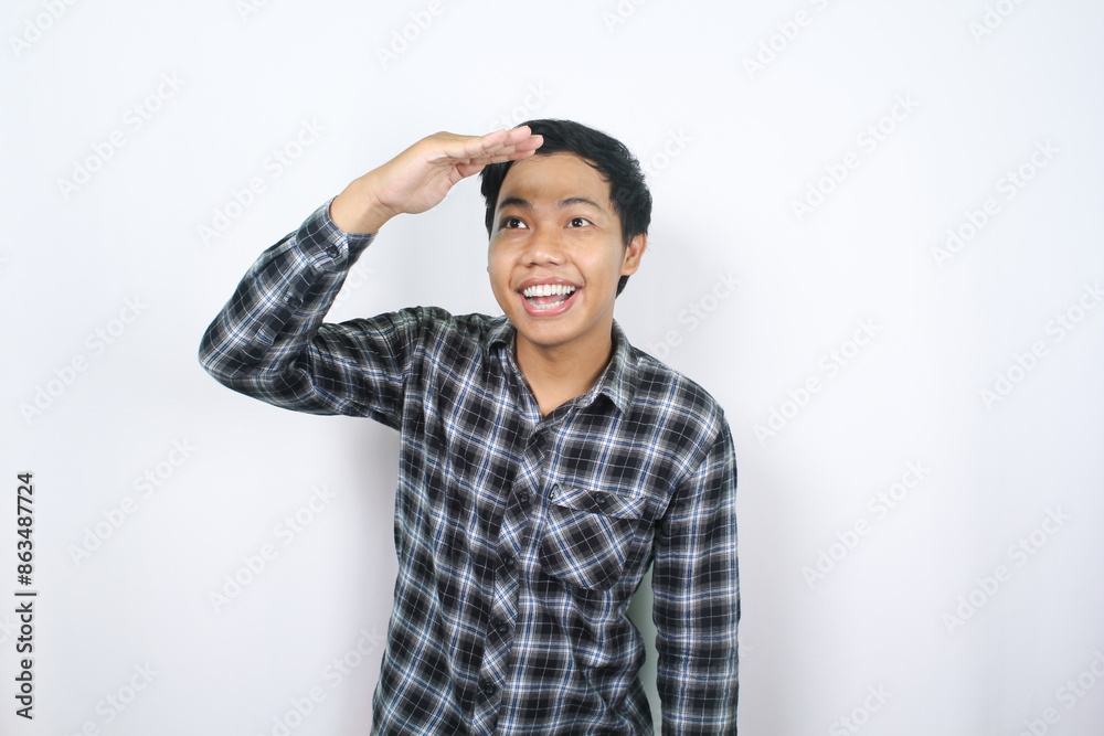 portrait of happy asian man raising hand over his head to gesturing look far away isolated portrait of happy asian man raising hand over his head to gesturing look far away isolated