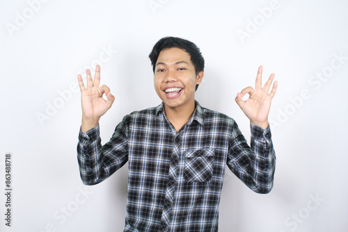 cheerful asian man showing ok sign with his finger isolated