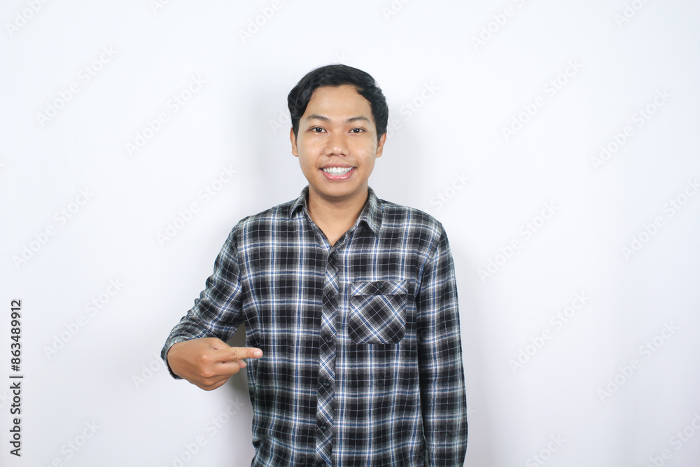 attractive asian man pointing finger to the middle with looking at camera isolated attractive asian man pointing finger to the middle with looking at camera isolated