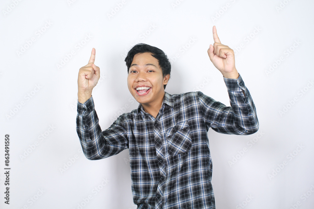 cheerful asian man smiling and pointing hand to above with looking at camera isolated cheerful asian man smiling and pointing hand to above with looking at camera isolated