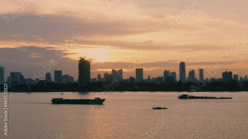 Silhouetted Cityscape of Phnom Penh at Sunset Over the River
